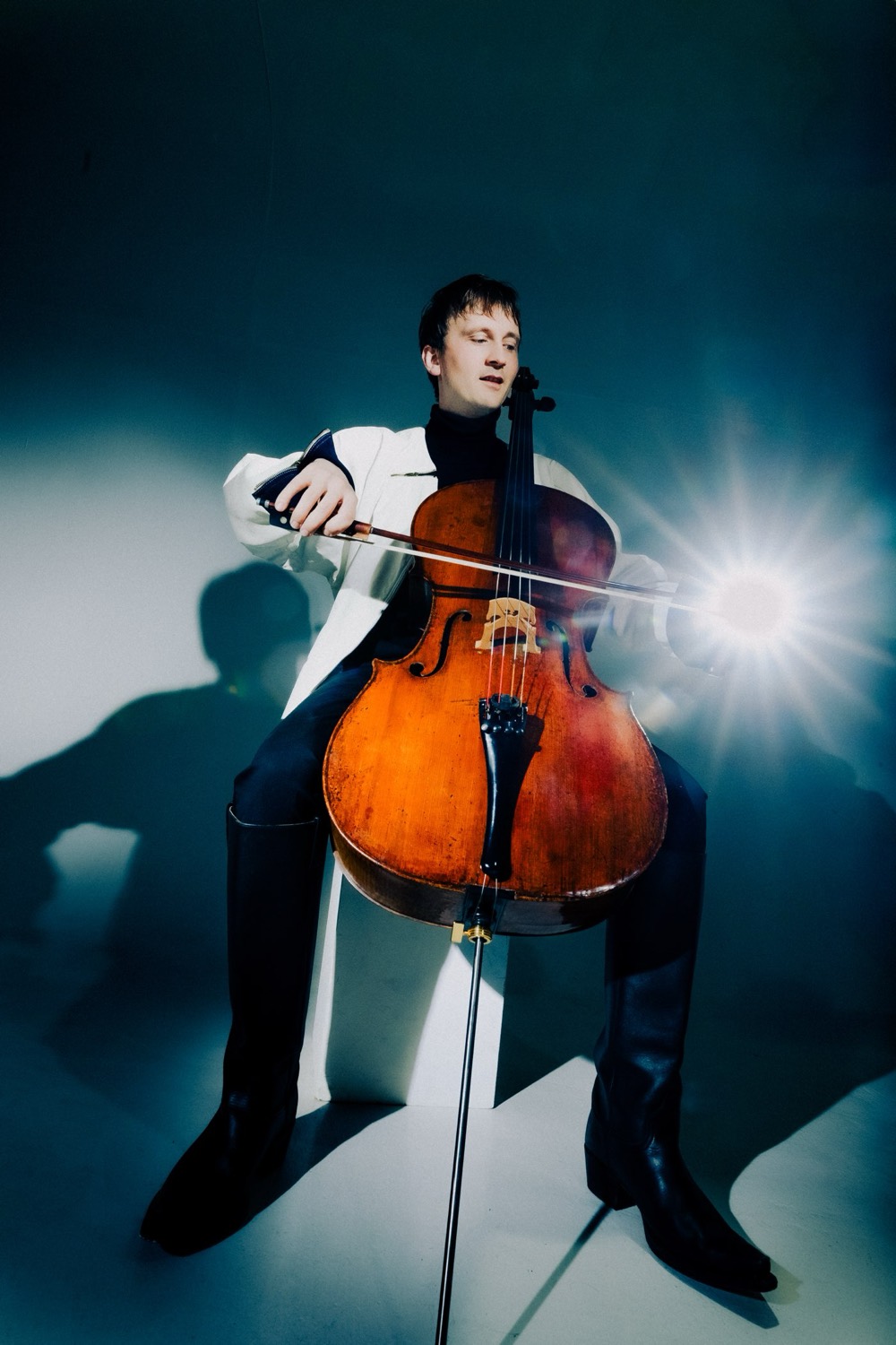 Benedict Kloeckner playing his cello in a beam of stage light